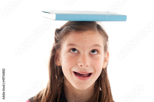 Photo: Symbolbild Bildung: Mädchen mit Buch auf dem Kopf Symbolbild Bildung: Mädchen mit Buch auf dem Kopf
