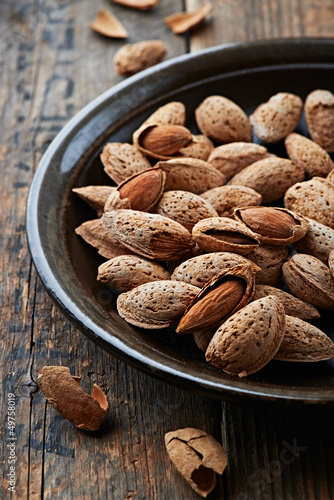 Photo: Almonds with shell on a ceramic plate Almonds with shell on a ceramic plate