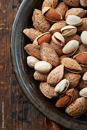 Photo: Almonds and pistachios on a ceramic plate Almonds and pistachios on a ceramic plate