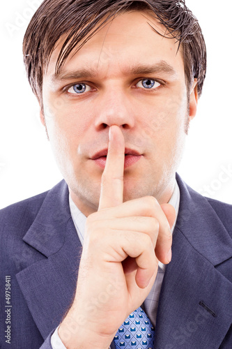 Photo: Portrait of businessman showing silence gesture with his forefin Portrait of businessman showing silence gesture with his forefin