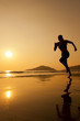 Silhouette of a woman running on th beach.