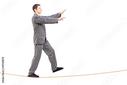 Photo: Full length portrait of a young man in pajamas sleepwalking on a Full length portrait of a young man in pajamas sleepwalking on a