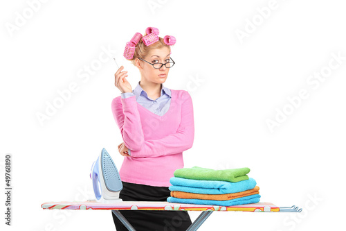 Photo: Housewife with hair rollers smoking a cigarette and posing behin Housewife with hair rollers smoking a cigarette and posing behin