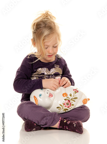 Photo: Kind mit Sparschwein beim sparen von Geld Scheinen Kind mit Sparschwein beim sparen von Geld Scheinen