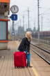 Frau wartet auf Bahnhof auf ihren Zug