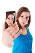 Foto: Young girl taking a self portrait with her phone Young girl taking a self portrait with her phone