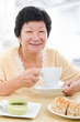 Asian senior woman having breakfast
