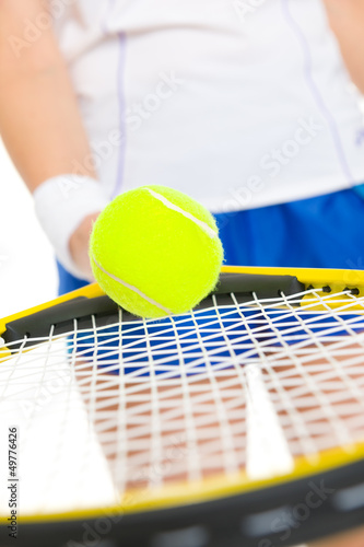 Photo: Closeup on tennis player balancing ball on racket Closeup on tennis player balancing ball on racket