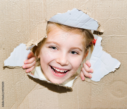 Photo: kid in torn paper hole kid in torn paper hole