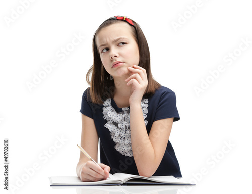 Photo: Schoolgirl thinks over the task, isolated Schoolgirl thinks over the task, isolated