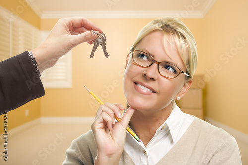 Photo: Woman Being Handed Keys in Empty Room with Boxes Woman Being Handed Keys in Empty Room with Boxes