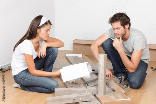 Photo: Couple moving in assembling bed furniture Couple moving in assembling bed furniture