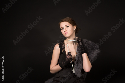Photo: The girl in the retro image of a black background The girl in the retro image of a black background
