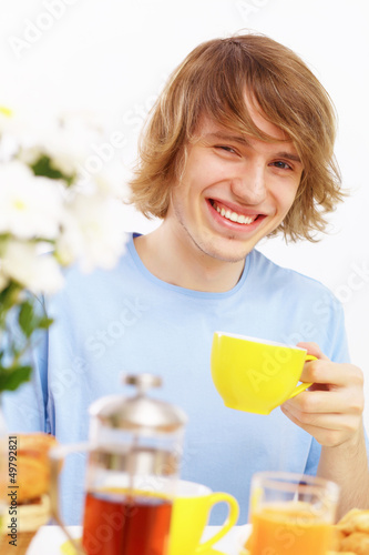 Photo: Young happy man drinking tea Young happy man drinking tea