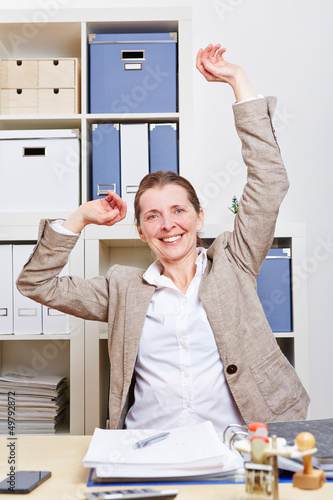 Photo: Frau im Büro macht Dehnübungen für den Rücken Frau im Büro macht Dehnübungen für den Rücken