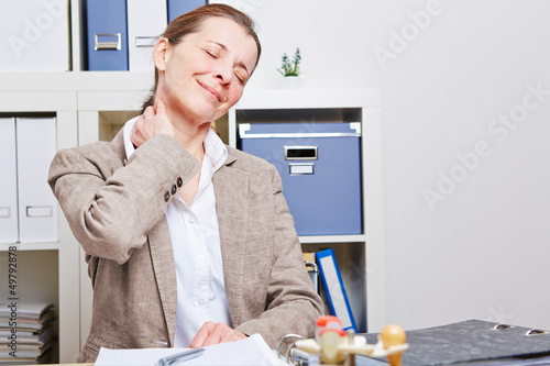 Photo: Frau mit Nackenschmerzen im Büro Frau mit Nackenschmerzen im Büro
