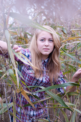 Photo: Closeup of young beautiful blond woman in reed Closeup of young beautiful blond woman in reed