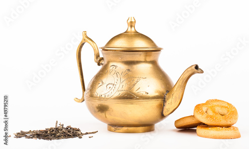 Photo: old brass teapot and sweet cookies isolated on white old brass teapot and sweet cookies isolated on white