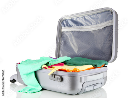Photo: Open silver suitcase with clothing isolated on white Open silver suitcase with clothing isolated on white