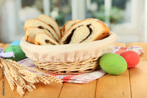 Photo: Loaf with poppy seed in wicker basket, on bright background Loaf with poppy seed in wicker basket, on bright background