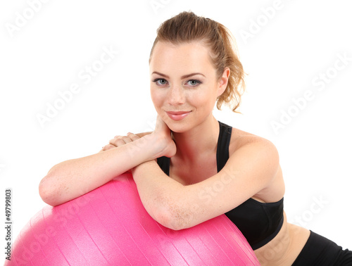 Photo: Young woman with gym ball isolated on white Young woman with gym ball isolated on white