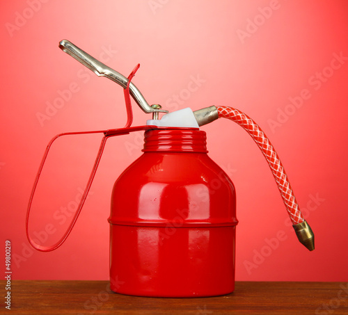 Photo: Oil can on red background Oil can on red background