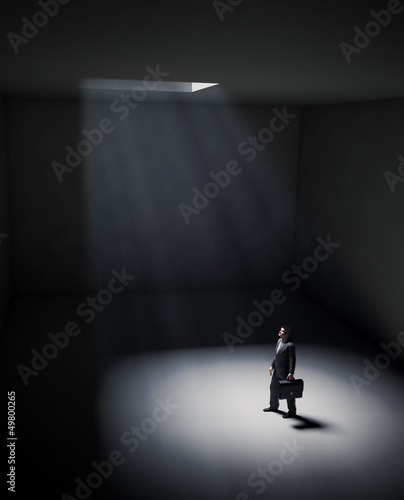 Illustration: A lonely man standing in a spot of light A lonely man standing in a spot of light