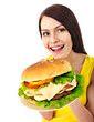 Woman holding hamburger.