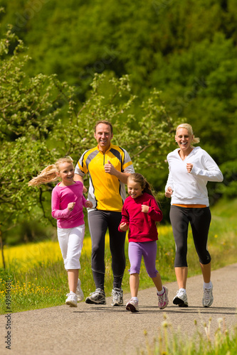 Photo: Family running in the meadow for sport Family running in the meadow for sport