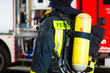 Feuerwehrmann steht in Uniform vor einer Feuerwehr