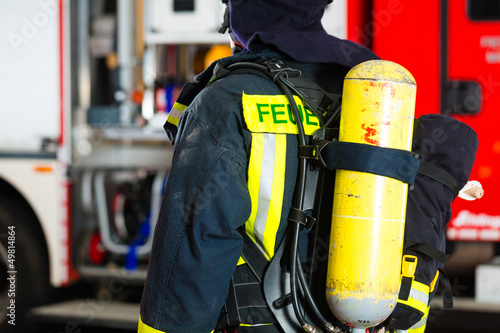Photo: Feuerwehrmann steht in Uniform vor einer Feuerwehr Feuerwehrmann steht in Uniform vor einer Feuerwehr