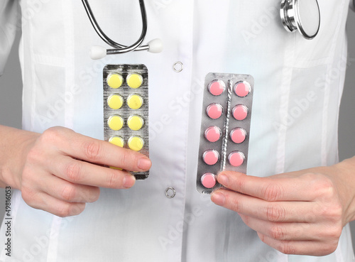 Photo: Close-up of female doctor hand holding pills, Close-up of female doctor hand holding pills,