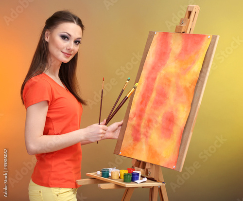 Photo: beautiful young woman painter at work, beautiful young woman painter at work,