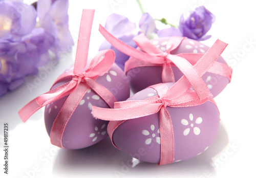 Photo: Bright easter eggs with bows and flowers, isolated on white Bright easter eggs with bows and flowers, isolated on white
