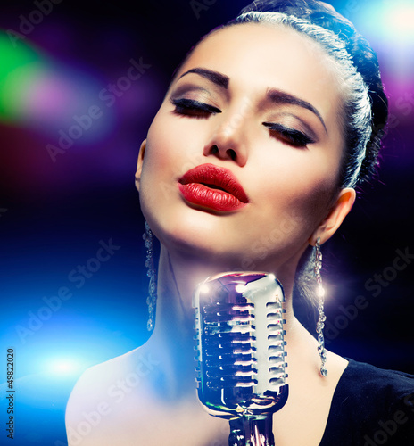 Photo: Singer Woman with Retro Microphone. Vintage Style Singer Woman with Retro Microphone. Vintage Style