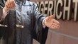 Rechtsanwalt mit Waage vor Gericht mit Handschlag