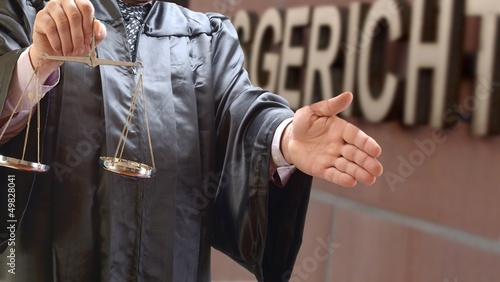 Photo: Rechtsanwalt mit Waage vor Gericht mit Handschlag Rechtsanwalt mit Waage vor Gericht mit Handschlag
