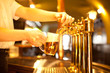 waiter is drafting a beer from a golden spigot