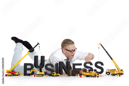 Photo: Business start up: Businessman building business-word. Business start up: Businessman building business-word.