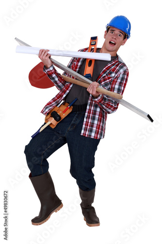 Photo: Overwhelmed tradesman carrying building supplies Overwhelmed tradesman carrying building supplies