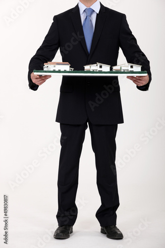Photo: Businessman holding a model of a housing estate Businessman holding a model of a housing estate