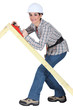Tradeswoman using a plane to smooth a wooden frame