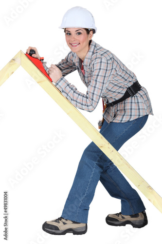 Photo: Tradeswoman using a plane to smooth a wooden frame Tradeswoman using a plane to smooth a wooden frame
