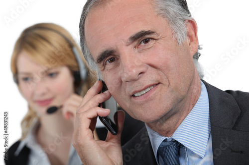 Photo: secretary and businessman working on the phone secretary and businessman working on the phone