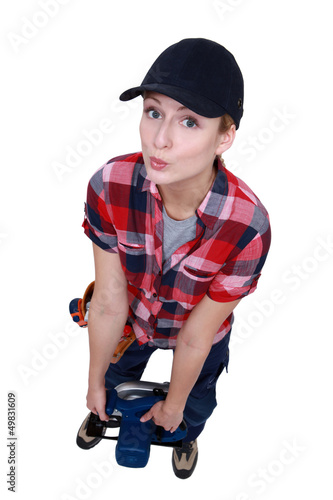 Photo: Blond worker struggling to carry circular saw Blond worker struggling to carry circular saw