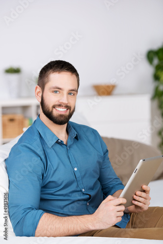 Photo: junger mann mit tablet zu hause junger mann mit tablet zu hause