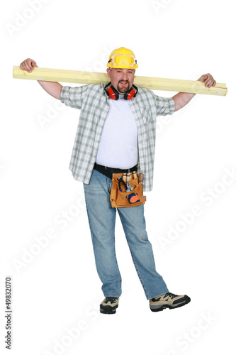 Photo: A carpenter holding a plank. A carpenter holding a plank.