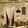 doorway to the tuscan house with striped outdoor curtain