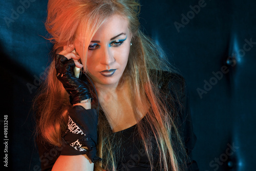 Photo: beautiful girl with a phone on a dark background beautiful girl with a phone on a dark background