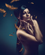 naked woman in blue dark with feathers